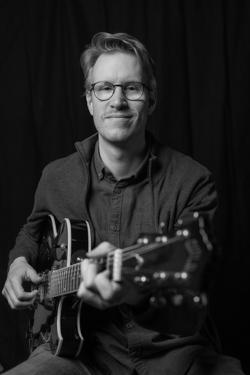 docent Elmer speelt gitaar